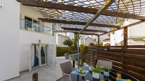 An outdoor patio with a wooden pergola, tables with plates and glasses, and a view of the surrounding buildings. - Your Beautiful Holiday Villa Minutes From the Beach, Protaras Villa 1492 (Paralimni)