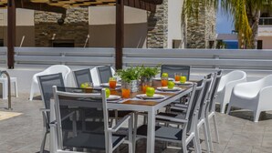 An outdoor dining area with white plastic chairs and tables, arranged in a row. - You and Your Family Will Love This 5 Star Villa With Private Pool, Protaras Villa 1500 (Paralimni)