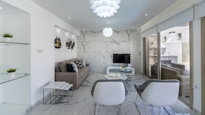 A modern living room with a sofa, two chairs, a coffee table, and a TV. - You and Your Family Will Love This 5 Star Villa With Private Pool, Protaras Villa 1500 (Paralimni)