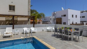 A rooftop pool area with a pool, lounge chairs, and a dining setup. - You and Your Family Will Love This 5 Star Villa With Private Pool, Protaras Villa 1500 (Paralimni)