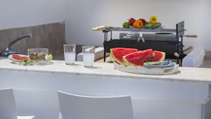 A kitchen area with a grill, a plate of watermelon, and glasses of water. - Imagine Your Family Renting This Luxury Villa Minutes From Fig Tree Bay, Protaras Villa 1426 (Paralimni)