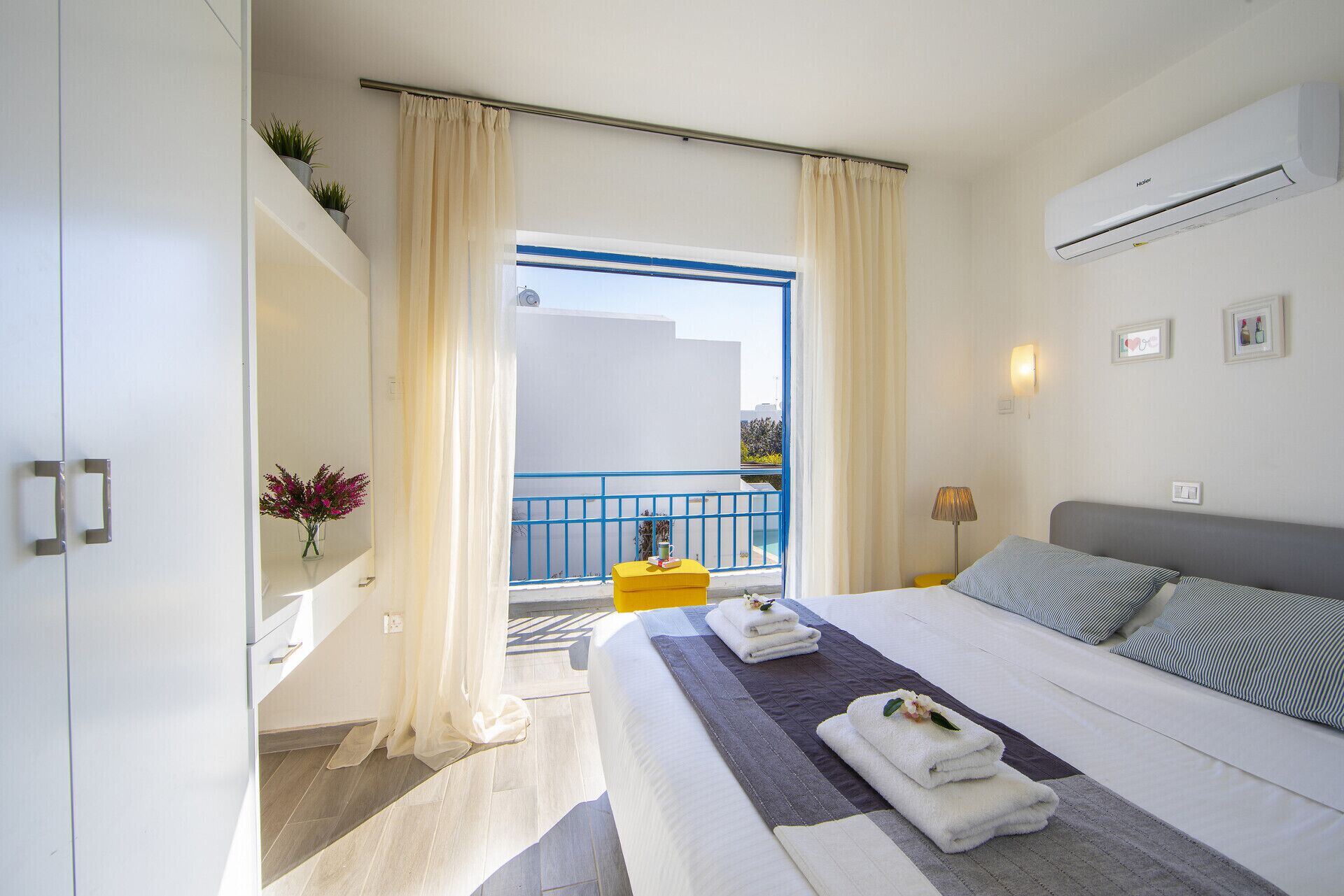 Un cuarto de hotel con cama, balcón y vista al mar.