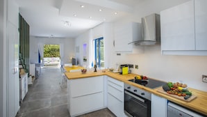 A modern kitchen with white cabinets, a wooden countertop, and a built-in oven. - Imagine Your Family Renting This Luxury Villa Minutes From Fig Tree Bay, Protaras Villa 1426 (Paralimni)