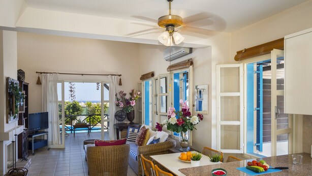A spacious kitchen with a dining area, a ceiling fan, and a view of the outdoors.