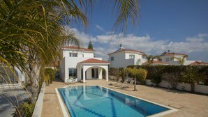 A swimming pool with a geometric tile pattern, surrounded by a patio area with lounge chairs and a covered seating area. - Your Beautiful Holiday Villa Minutes From Beautiful Beaches, Ayia Napa Villa 1370 (Sotira)
