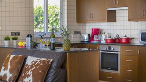 A modern kitchen with wooden cabinets, a Bosch oven, and a red kettle. - Your Beautiful Holiday Villa Minutes From Beautiful Beaches, Ayia Napa Villa 1370 (Sotira)