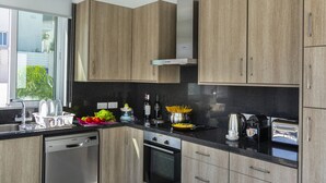 A modern kitchen with wooden cabinets, a dishwasher, an oven, and various kitchen appliances. - At Last You can Rent the Perfect Luxury Villa, Protaras Villa 1494 (Paralimni)