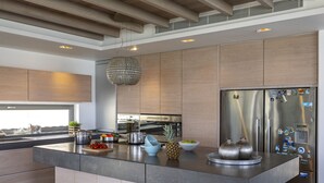 A modern kitchen with a central island, stainless steel appliances, and a hanging light fixture. - You and Your Family Will Love This Beachfront Villa, Protaras Villa 1526 (Paralimni)