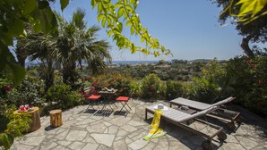 An outdoor patio with stone flooring, wooden furniture, and a view of the landscape. - Discover Perfect Holiday Escape in Protaras, 1411 (Paralimni)