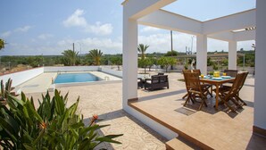 A covered outdoor area with a pool, dining table, and chairs. - Imagine Your Family Renting This Luxury Villa With Large Private Pool, Protaras Villa 1543 (Paralimni)