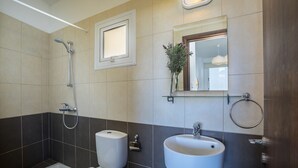Une salle de bain équipée de toilettes, d’un bidet et d’un lavabo.