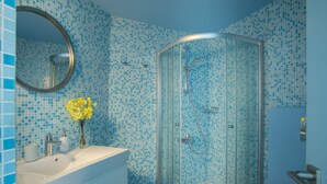 Une salle de bain avec une douche, un lavabo et un miroir.