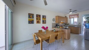 Una cocina moderna con armarios de madera, una mesa de comedor con sillas y una isla central.