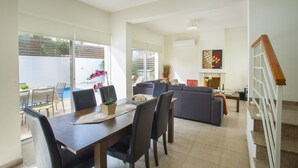 A spacious living area with a dining table, sofas, and a staircase. - Unforgettable 5-star Escape: Protaras Villa 1476 (Paralimni)