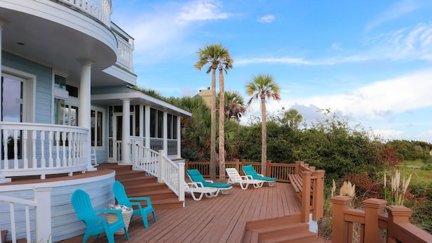 A wooden deck with lounge chairs and a potted plant. - Oceanfront / Sleeps 16 / Beach Days / Screen Porch (Isle of Palms)