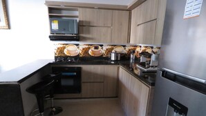 A modern kitchen with a microwave, coffee machine, and a water dispenser. - Villa del Socorro (Jardín)