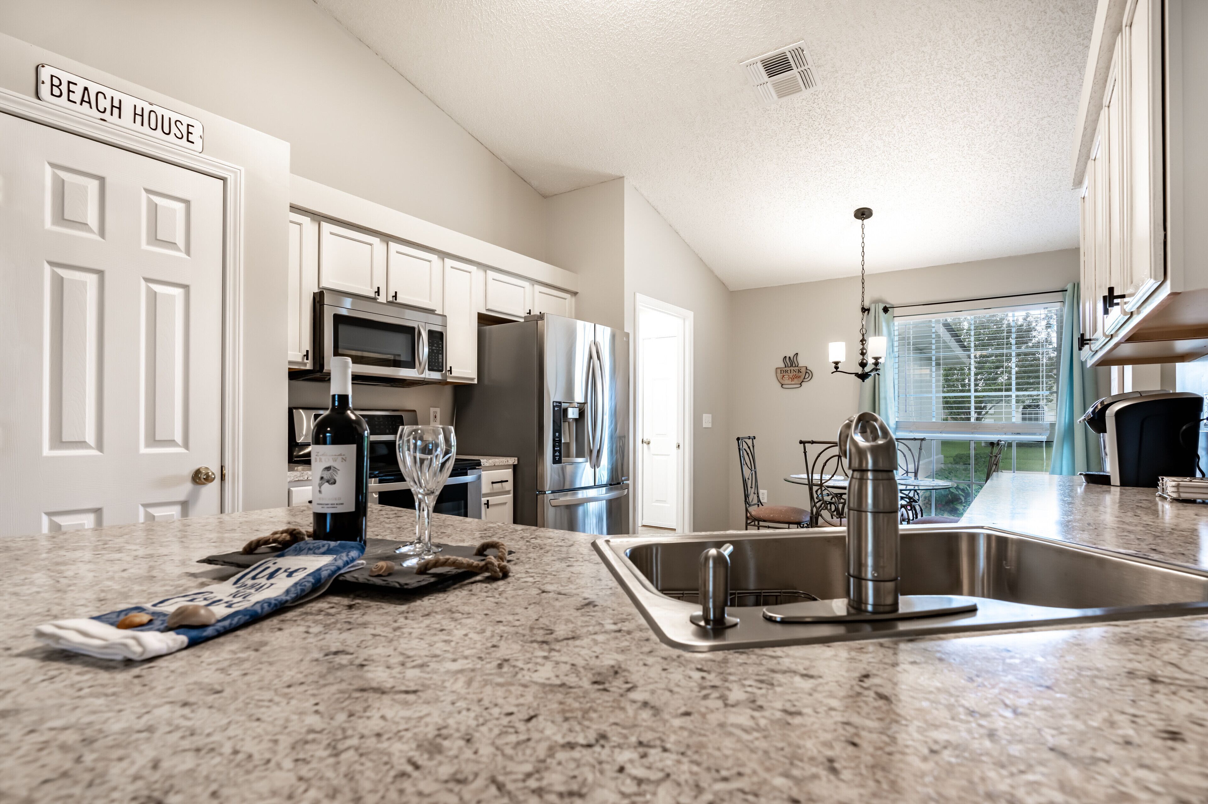A kitchen with white cabinets, stainless steel appliances, and a granite countertop.