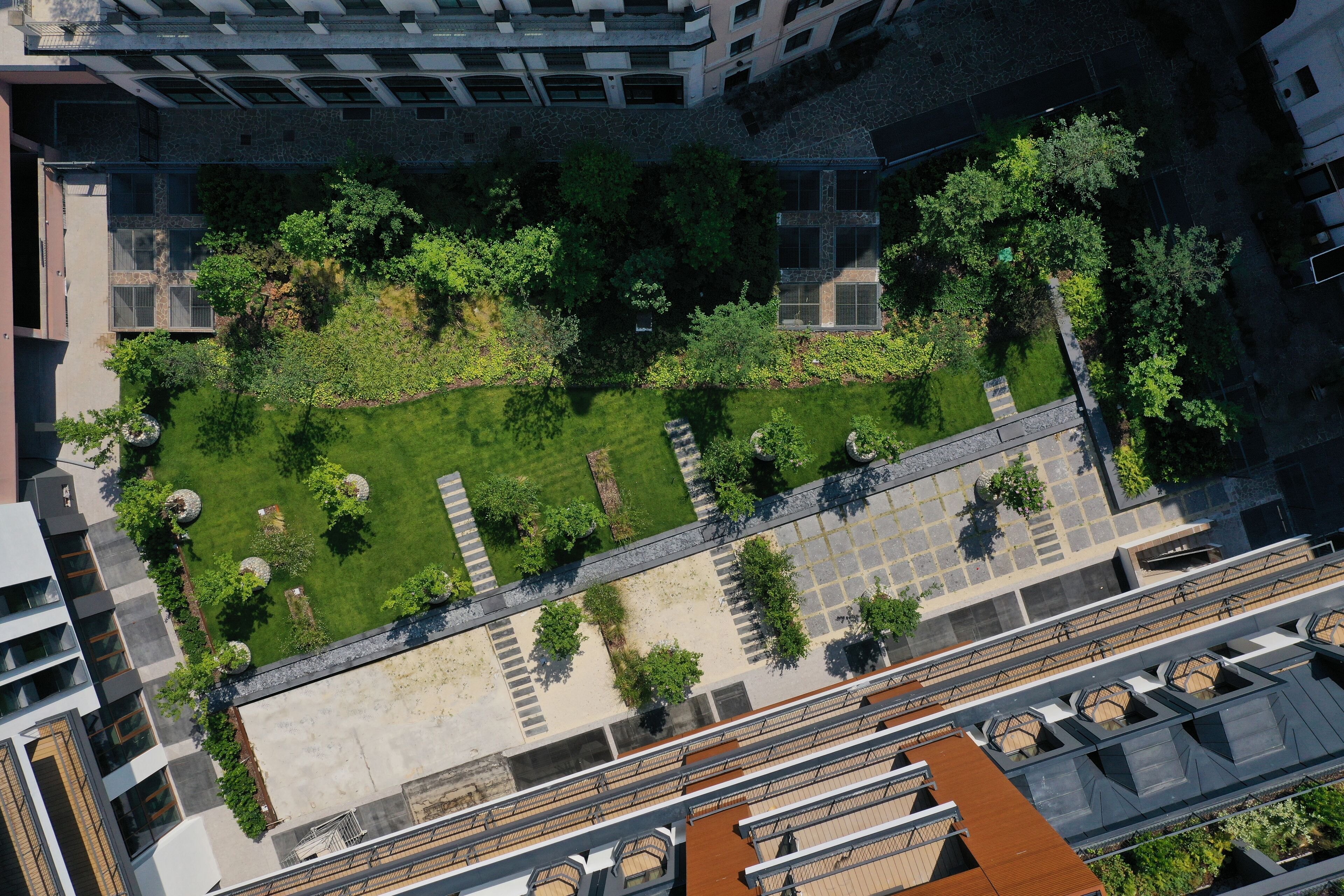 An aerial view of a courtyard with a central lawn, surrounding buildings, and a pathway.