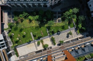 An aerial view of a courtyard with a central lawn, surrounding buildings, and a pathway.