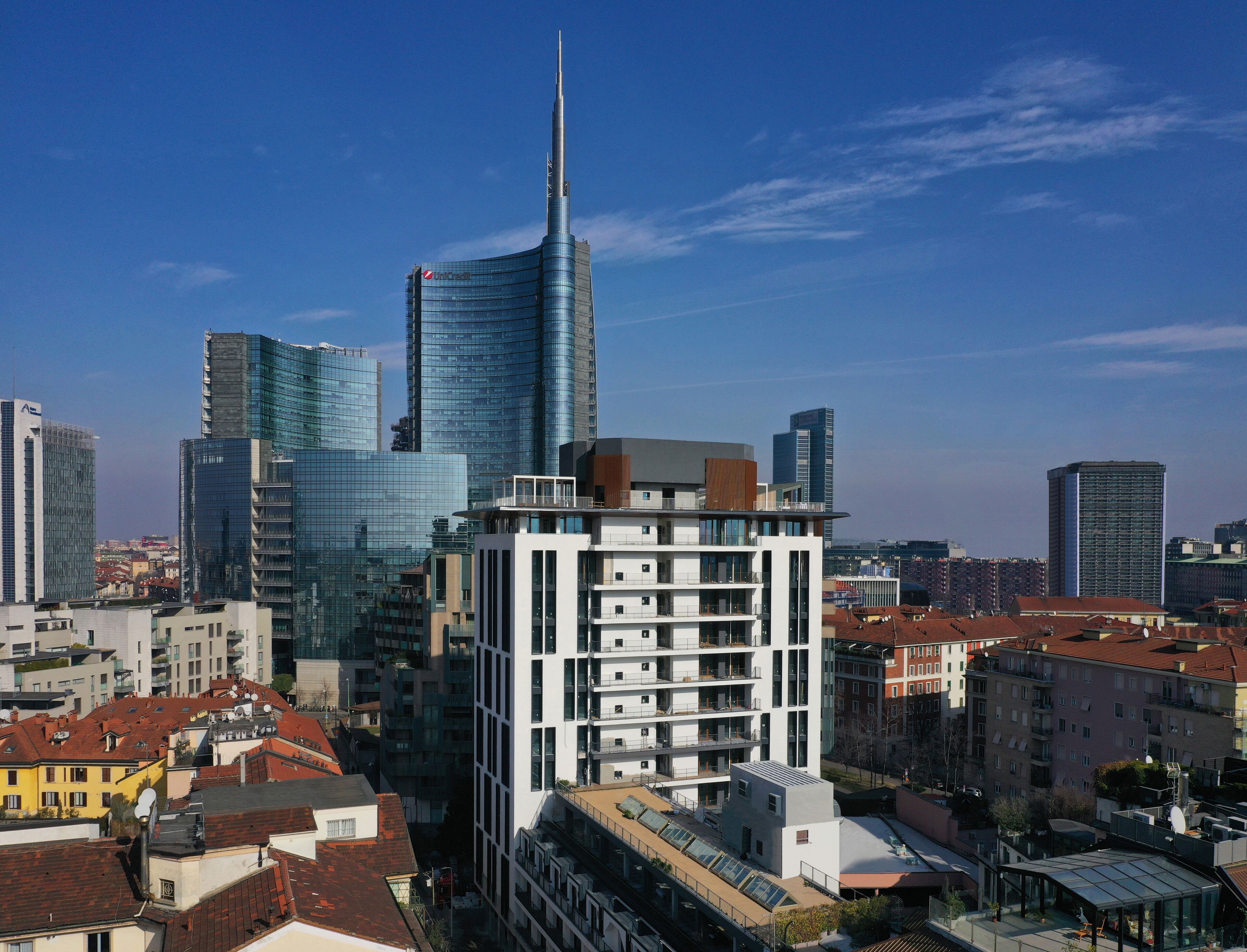 Un paisaje urbano moderno con edificios altos, incluyendo un rascacielos destacado con aguja.