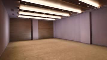A spacious room with a carpeted floor, wooden panel walls, and recessed lighting.