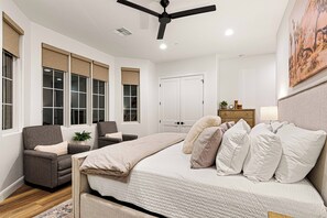A bedroom with a bed, a chair, a desk, a ceiling fan, and a door. - 5 Suites, Private Pool, 2 Hot Tubs for 19, 2 Fire Pits, 2 Fridges Sleeps 30 (Hurricane)