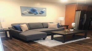 A living room with a sectional sofa, a coffee table, and a rug.
