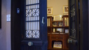 Una puerta de madera oscura con un panel de vidrio decorativo y un picaporte.