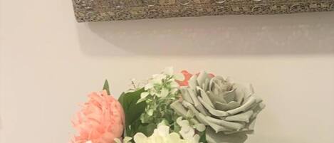 A table with a textured grey tablecloth and a vase with flowers.