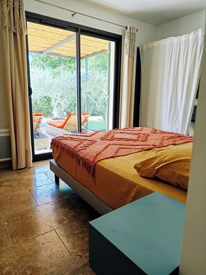 Une chambre avec un lit, une vue sur l’extérieur et une porte-fenêtre coulissante.