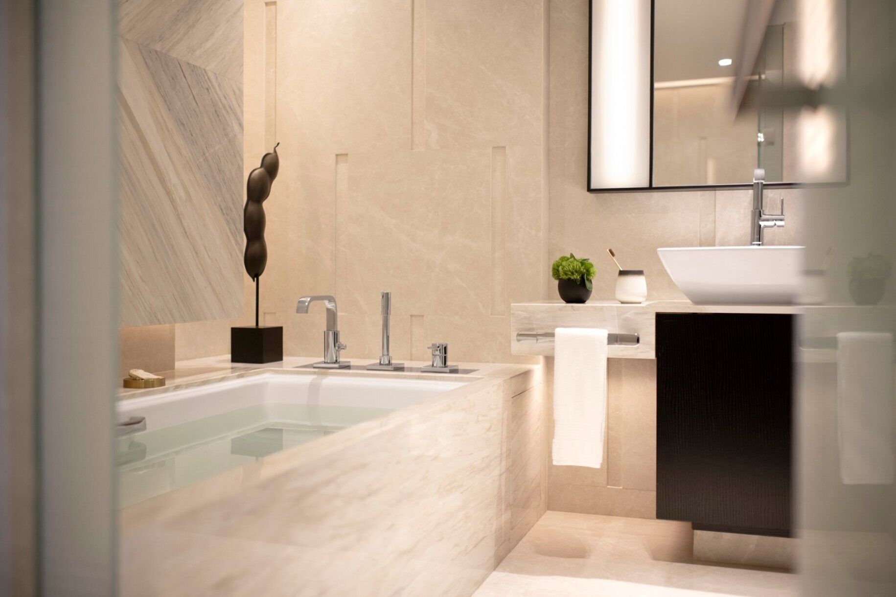 A modern bathroom with a freestanding bathtub, a large mirror, and a minimalist sink area.