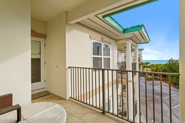 A balcony with a view of the ocean, a door, and a chair. - Legacy 501 - Seagrove Beach, Gulf Views, Two Community Pools! (Seagrove Beach)