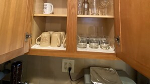 A kitchen with wooden cabinets, a kettle, mugs, and a toaster. - Charming 2nd Floor Haven (Westfield)
