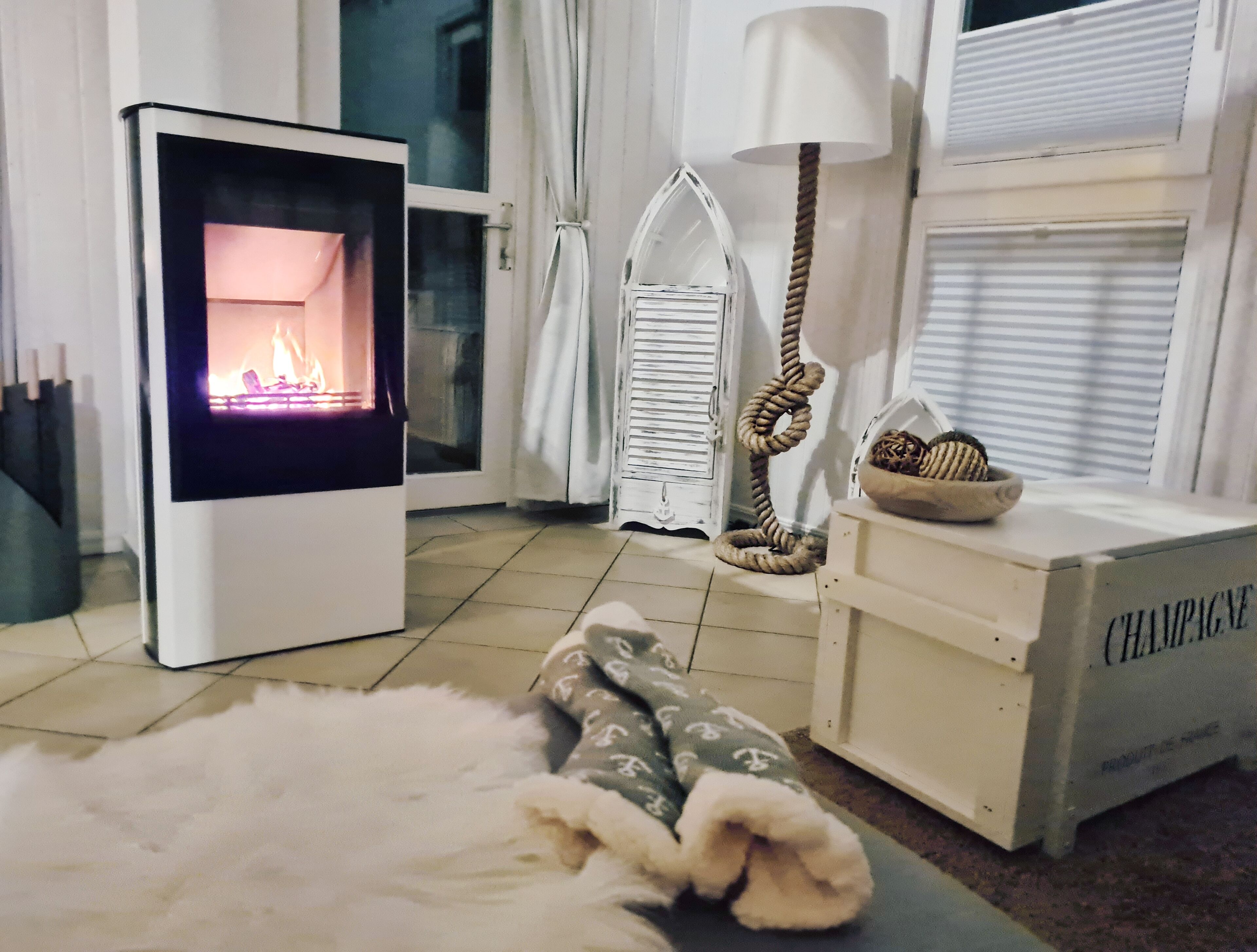 Ein gemütliches Zimmer mit Kamin, einer Lampe und einer Kiste mit dem Aufdruck „Champagner“.