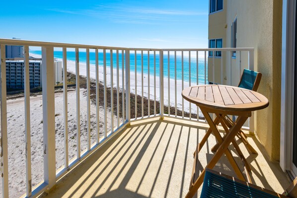 Ein Balkon mit Blick auf Strand und Meer.