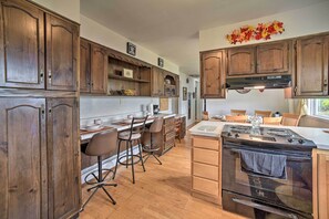 Enjoy cooking and dining in this well-equipped kitchen with a central island, stove, sink, and ample counter space.