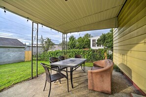Enjoy outdoor dining or socializing in a, serene setting with a table and chairs on the covered patio.