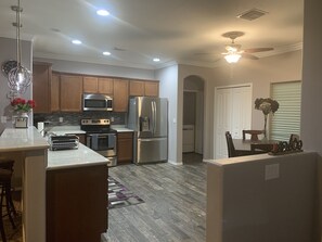 Enjoy cooking in this well-equipped kitchen with a microwave, oven, and refrigerator, and dine at the adjacent table.