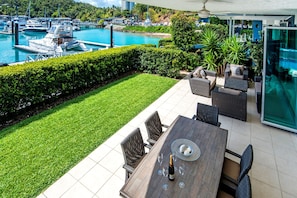Relax on the patio with wicker furniture and enjoy a meal at the glass-topped dining table.