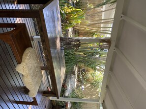 Relax on the deck surrounded by lush greenery and a serene garden view.