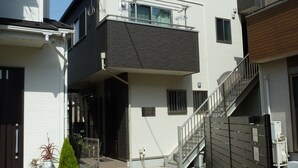 A modern two-story residential building with a balcony, a gated entrance, and a staircase leading to the upper floor. - Kanaloa Funabashi (Funabashi)