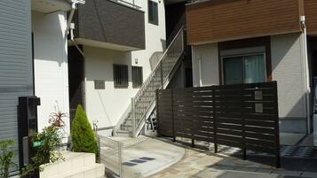 A residential area with modern houses, a gated entrance, and a small staircase leading to a balcony.