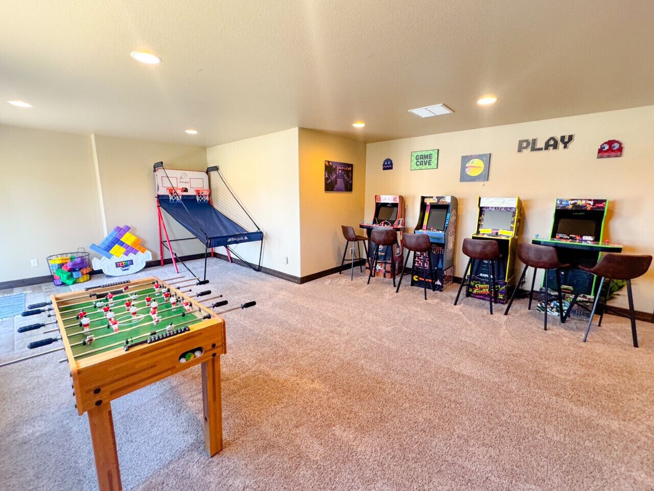 Ein Zimmer mit einem Kicker, einem Mini-Basketballkorb und Spielautomaten.
