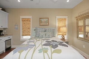 Relax in this serene bedroom with a large bed, framed picture, and stylish lamp.