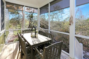 Relax in a serene outdoor space with a table and chairs, surrounded by lush views of the surrounding trees and landscape.