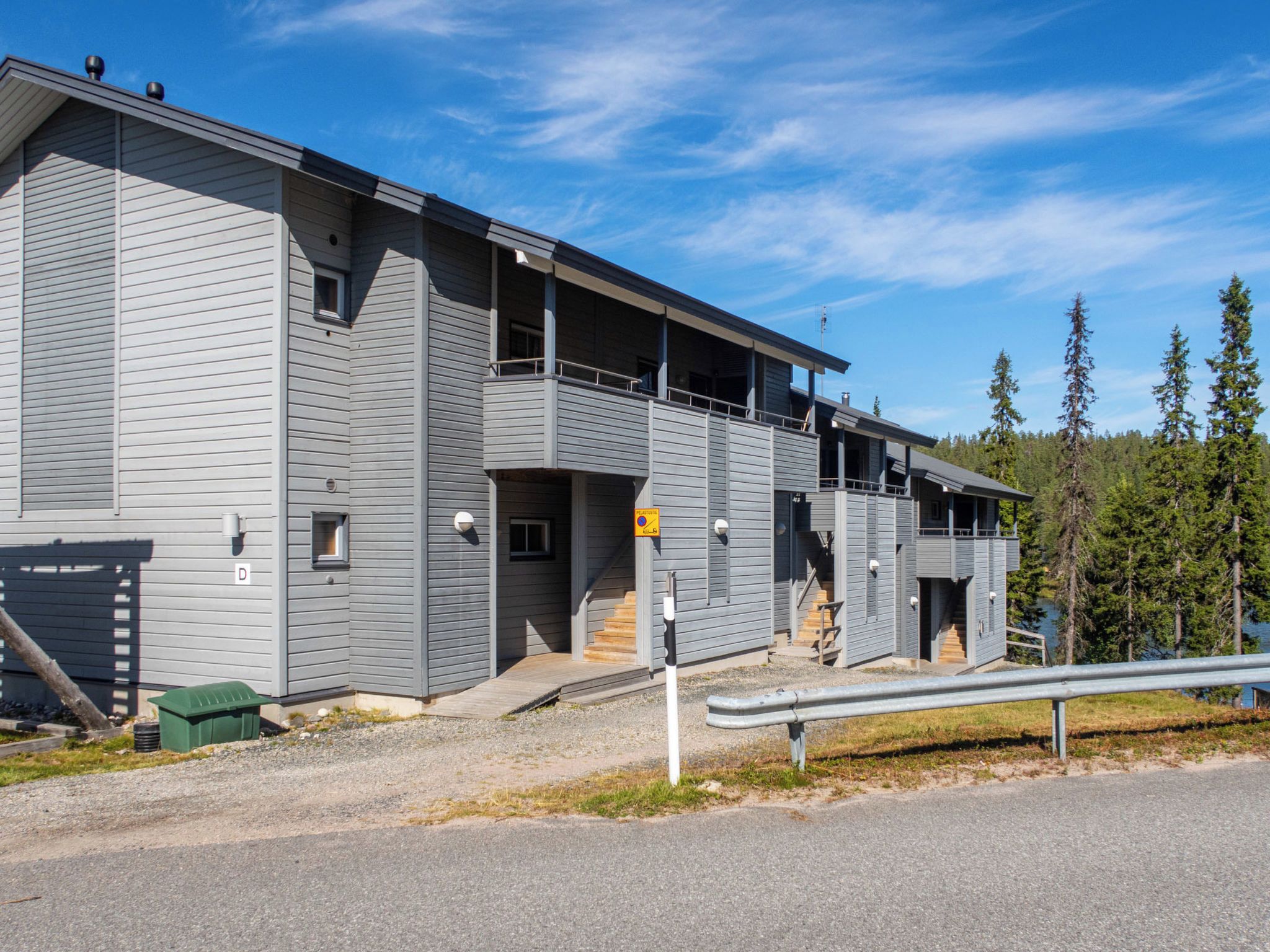 A multi-story building with a flat roof and a balcony on the upper floor.