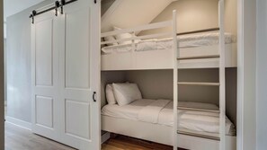 A bunk bed with a pull-down ladder, a white wardrobe with a sliding door, and a wooden floor. - Golf Cart Included! Walk or Bike to Beach & Pool! ~ Crew Rest at 30A Townhomes on 30A (Santa Rosa Beach)