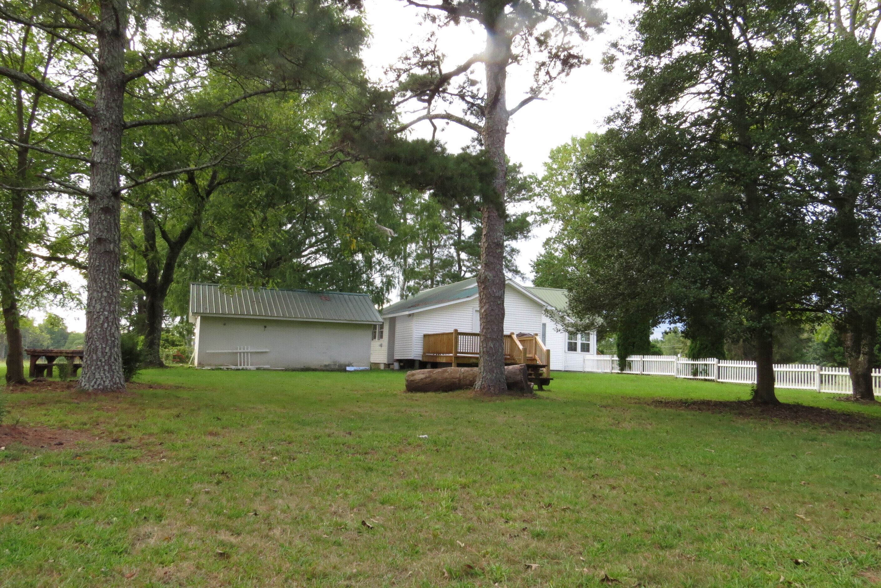 A house with a garage, a wooden deck, and a fenced yard.