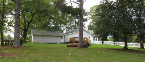A house with a garage, a wooden deck, and a fenced yard.