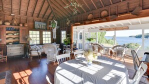 Un chalet confortable avec un intérieur en bois, un coin repas avec une table dressée pour deux personnes et une vue sur le lac.